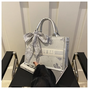 Détail du sac cabas métallisé argenté avec foulard en soie et motifs papillons et étoiles