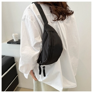 Back view of a casual black canvas chest bag for women with woven zipper pullers
