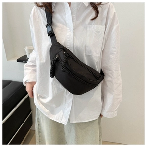 Close-up of minimalist black waist bag with adjustable strap and sturdy plastic buckle