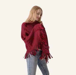 Detail of red and black chunky knit shawl with long fringe tassels and a retro design