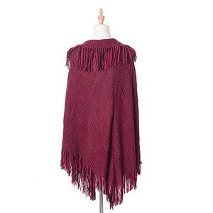 Detail shot of the red and black knit shawl featuring thick texture and long tassels