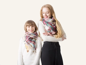 Detail of red and blue plaid cashmere-like scarf with soft tassels for family