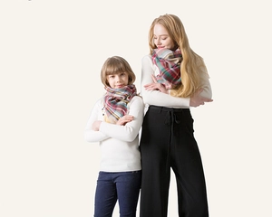 Detail of soft cashmere-like plaid scarves showing classic checkered pattern and fringe edges