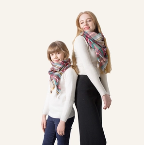 Close-up of matching parent-child plaid cashmere-like scarves with fringe details