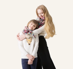 Detail of soft plaid cashmere-like triangle scarf with tassels for mom and kids outfits