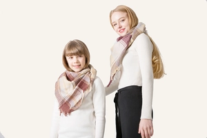 Detail of plaid cashmere shawl with tassels in burgundy and beige for parent and child