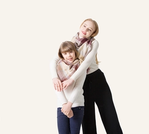 Close-up of cozy plaid scarves with soft fringes on family models for winter styling
