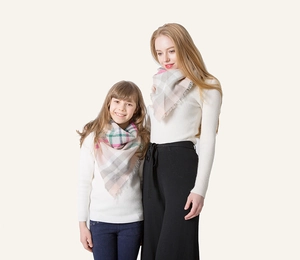 Detail of plaid cashmere-like triangle scarves for mother and child with soft fringes