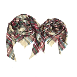 Detail of plaid scarf featuring fringed edges and woven texture in classic Scottish tartan