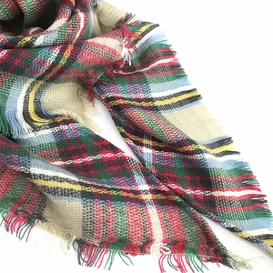 Close-up of thick plaid cashmere scarf texture featuring soft colorful tassels and fringe