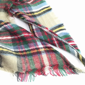 Detailed macro view of the colorful plaid cashmere-like texture and soft fringed edges
