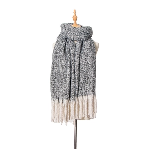 Detailed view of thick knit winter scarf with grey-white marl weave and long white tassels