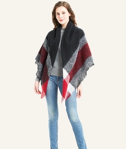 Detail of soft knit plaid scarf with fringe edge in black, red, and grey classic pattern