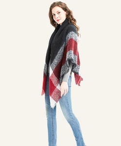 Close-up of the red and black plaid shawl with soft fringe trim and knitted texture
