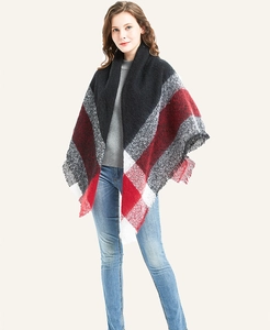 Detail of red and grey oversized plaid knit shawl with soft fringed edges for winter