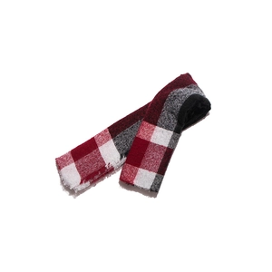 Detail of red and black plaid scarf fabric with frayed edges and soft textile texture