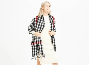 Close-up of classic red and black plaid scarf texture with soft fringe details