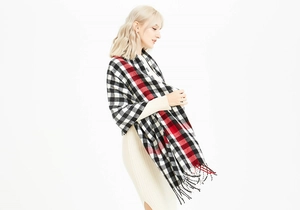 Macro detail of red and black plaid scarf showing soft cashmere-like texture and fringes
