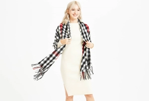 Detail of soft plaid scarf with fringe tassels in classic black white and red checkered pattern