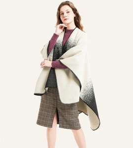 Detailed view of women's thick cashmere poncho featuring black and white gradient knit