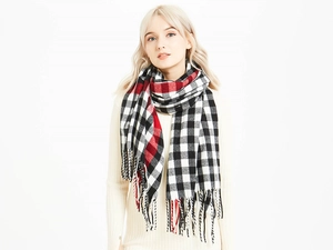 Detail of red and black buffalo plaid scarf with soft fringe edges for winter warmth