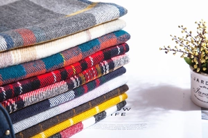 Close-up of neatly folded colorful plaid scarves with soft cashmere-like fabric texture