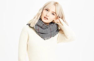 Close-up of classic red and black plaid scarf with fringe detail on female model