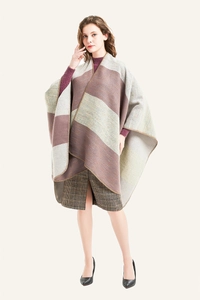 Detail of striped knitted poncho with refined edge finish and warm autumn colors