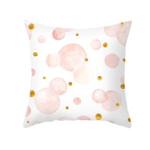 Close-up of pink and gold polka dot pattern on peach skin fabric cushion cover