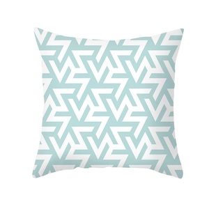 Close-up of geometric mint green and white pattern on modern peach skin pillowcase