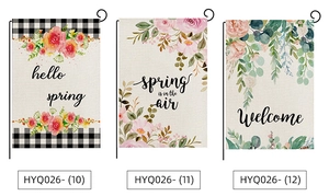 Detailed view of spring garden flags with watercolor flowers and welcome text in linen texture