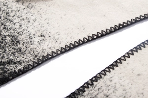 Close-up of overlock stitching and black and white gradient texture on cashmere-like shawl