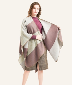 Detail of color-block knit poncho featuring high-density overlock edges and soft texture