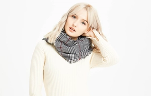 Close-up of houndstooth scarf with red accents and soft fringe edges for winter
