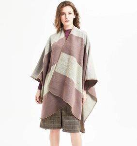 Detail of multi-color striped knitted poncho with fine edge stitching and split hem