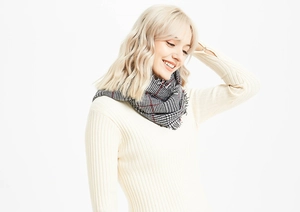Detail shot of soft cashmere-feel scarf with classic British red and black houndstooth pattern