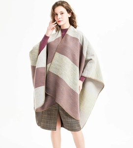 Detail of striped knitted poncho with split hem and dense overlock stitching finish