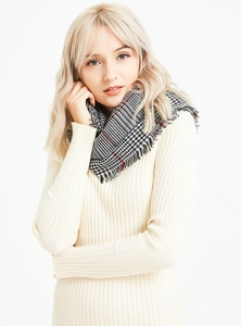 Detail of soft houndstooth cashmere feel scarf featuring classic red black fringe