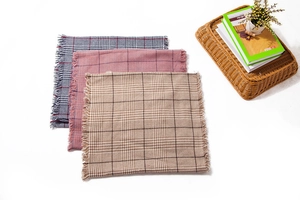 Detail view of plaid scarves showing soft fringe edges and classic checkered patterns