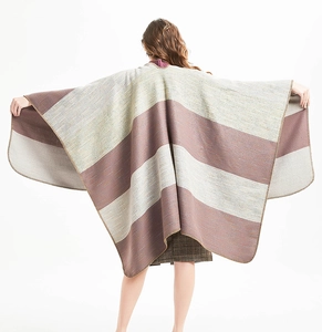 Rear view of oversized striped knit shawl featuring wide brown bands and overlock stitching