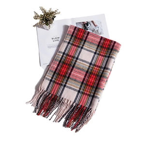 Close-up of red and beige plaid scarf with fringe tassels and cashmere-like texture
