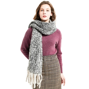 Thick black and white knit scarf with chunky cream tassels for winter warmth