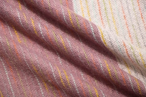 Macro detail of multicolored striped knit fabric with soft texture and vibrant purple base