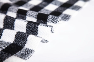 Close-up of thick black and white checkered knit fabric showing soft woven texture