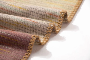 Macro detail of striped pashmina shawl featuring decorative yellow whipstitch edges