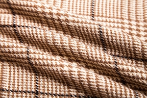 Macro shot of brown cashmere feel plaid fabric with intricate Prince of Wales check pattern