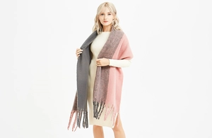 Gros plan d'une écharpe épaisse bicolore gris et rose avec de longues franges douces