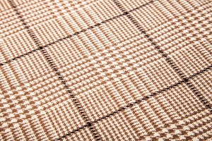 Macro view of soft glen plaid fabric texture in brown and beige for autumn scarves