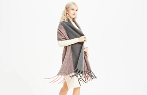 Détail de la maille épaisse et des franges sur l'écharpe bicolore gris et rose