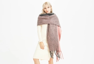 Détail d'une écharpe épaisse en tricot avec franges en blocs rose et gris foncé